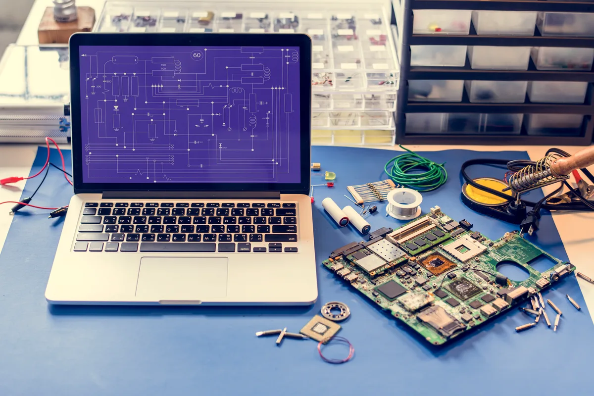 Technician performing component-level motherboard repair under a microscope