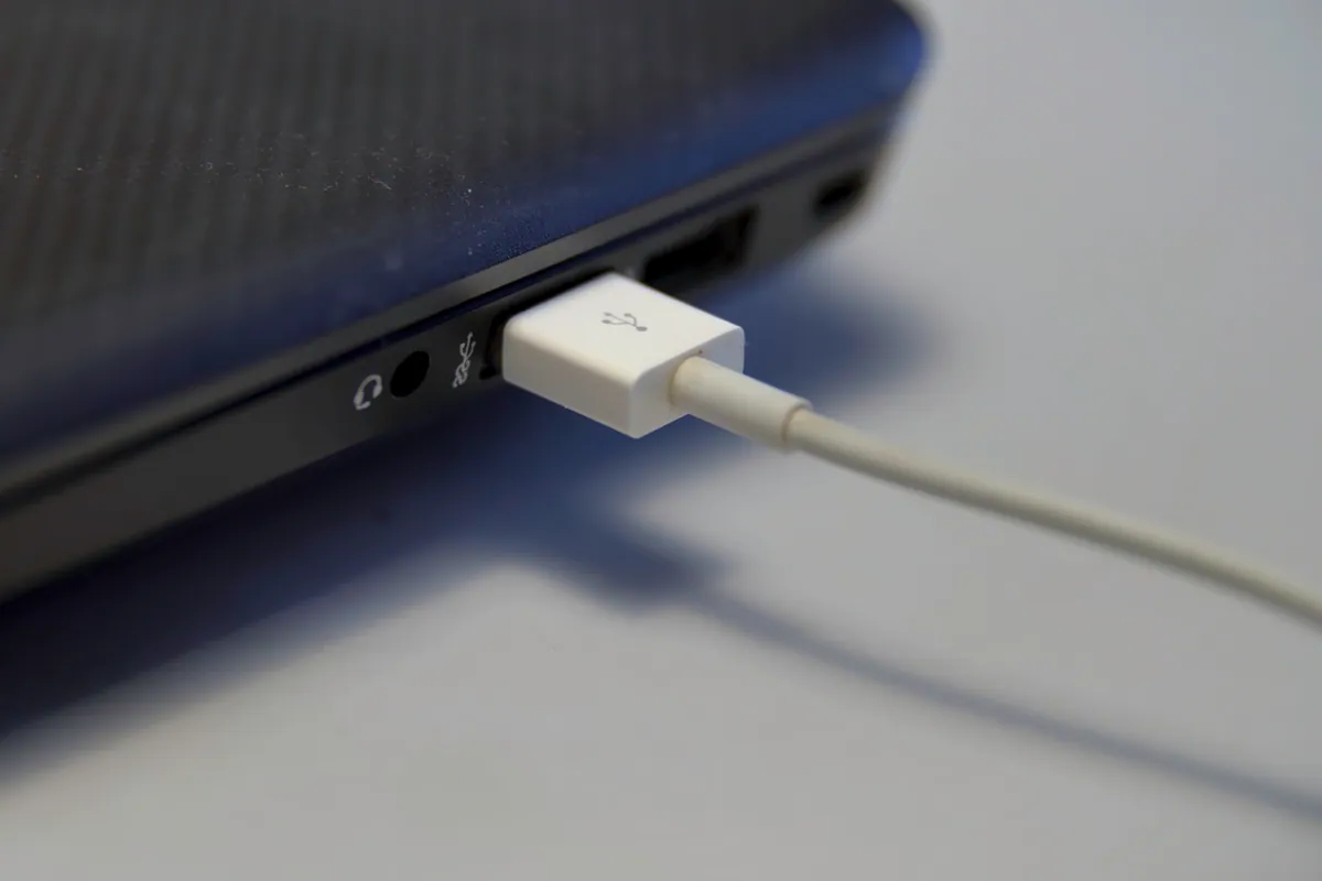 Inserting a USB cable into a laptop