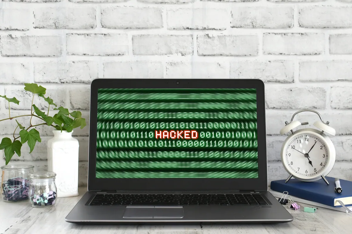 A laptop showing a hacked warning