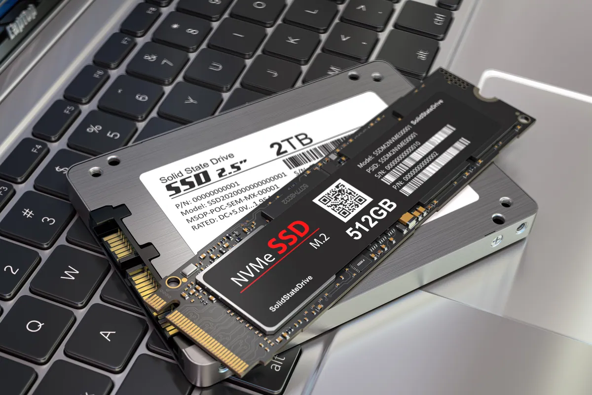 Different types of SSD drive beside a laptop