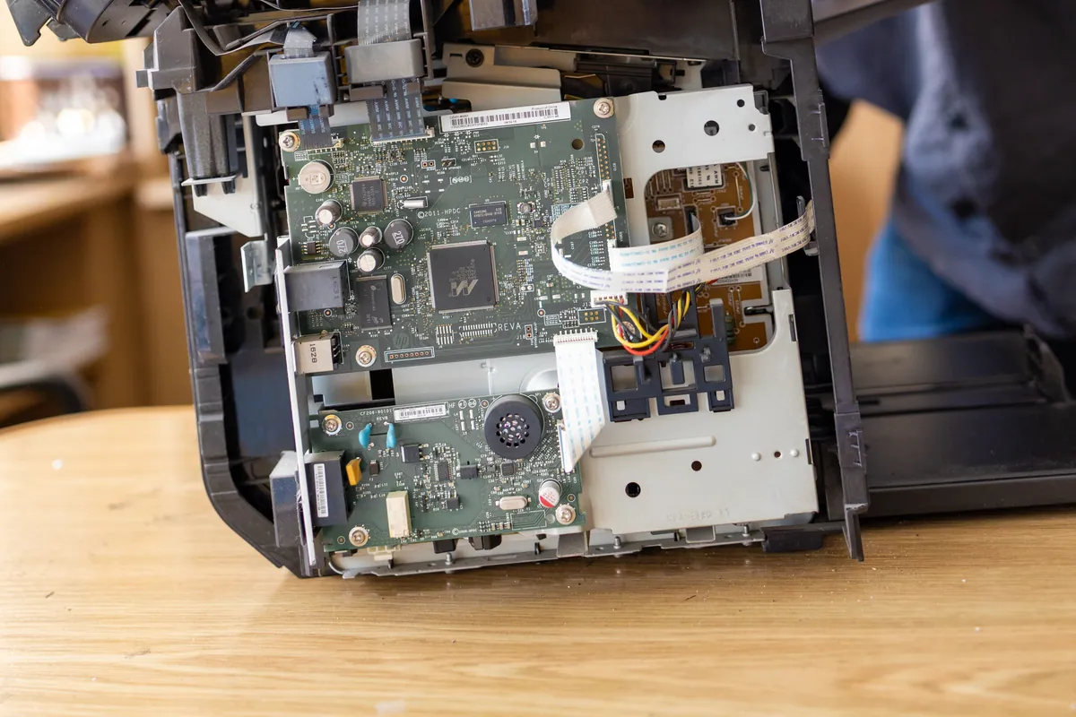 Technician inspecting an inkjet printer during a waste-ink-pad service