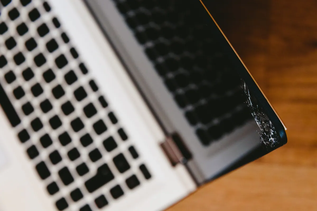 A laptop with a visibly cracked and broken screen