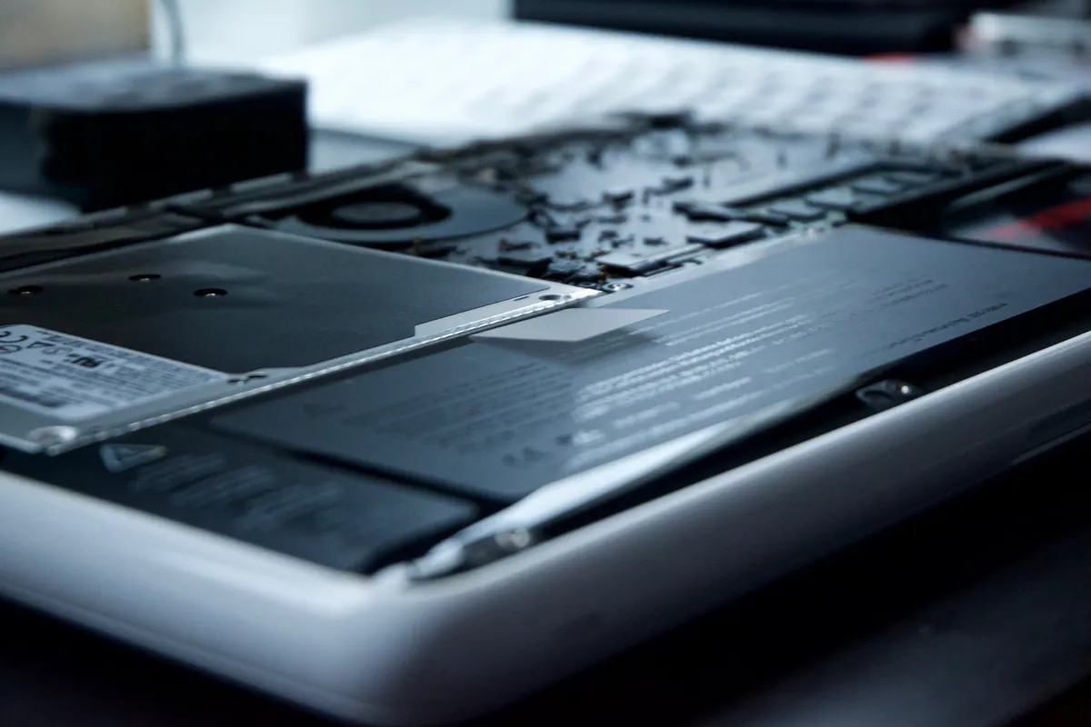A laptop opened up on the bench during a repair