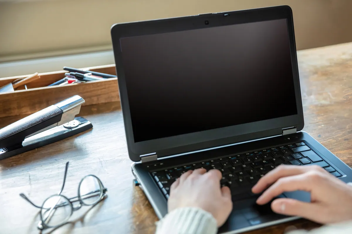 A laptop with a black, blank screen while powered on