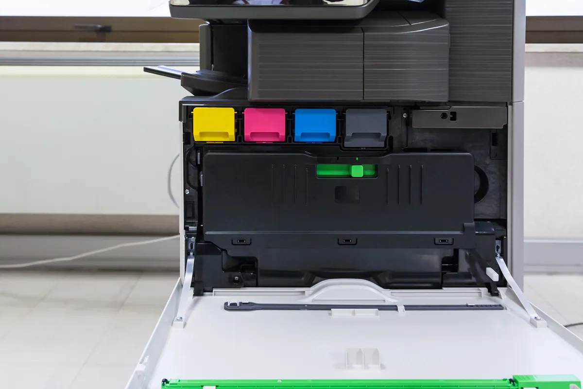 A multi-function office printer with ink cartridges, serviced for a paper jam