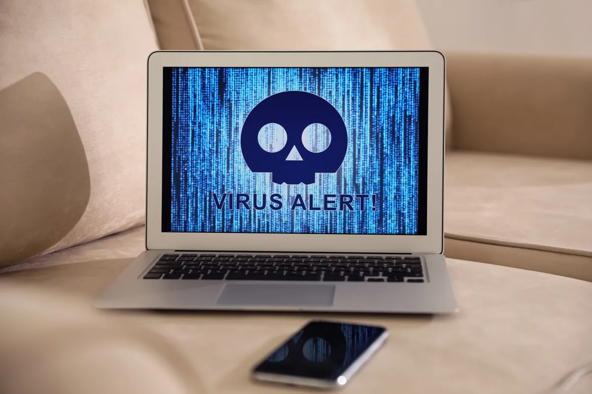 A phone and laptop showing virus warning popups